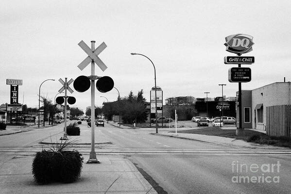 Weyburn Art Print featuring the photograph main road and railway crossing in downtown weyburn Saskatchewan Canada #1 by Joe Fox