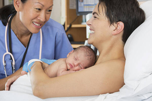 Expertise Art Print featuring the photograph Nurse comforting mother and newborn in hospital #1 by Ariel Skelley