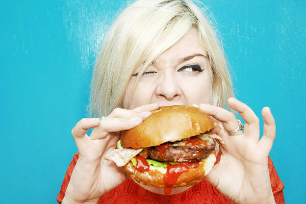 Unhealthy Eating Art Print featuring the photograph Woman Eating Hamburger #1 by Tara Moore