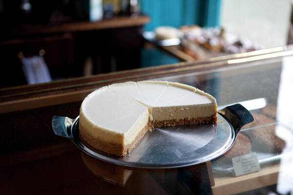 Unhealthy Eating Art Print featuring the photograph A Cheesecake Cut Into Slices On A by Halfdark