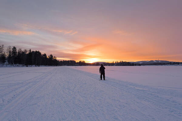 Ski Pole Art Print featuring the photograph A man skiing into the sunset by Sami Hurmerinta