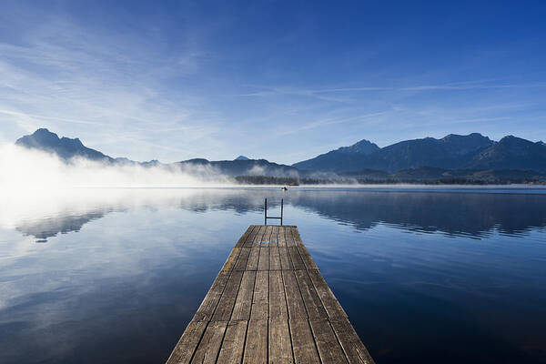 Tranquility Art Print featuring the photograph A wooden jetty on Lake Hopfensee at sunrise by Jorg Greuel