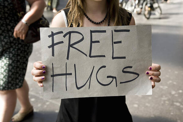 Zurich Art Print featuring the photograph A young woman holding a sign saying Free Hugs by Tobias Titz