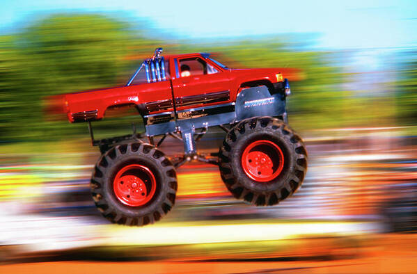 Photography Art Print featuring the photograph Big Wheeled Red Truck Jumping Blurred by Vintage Images