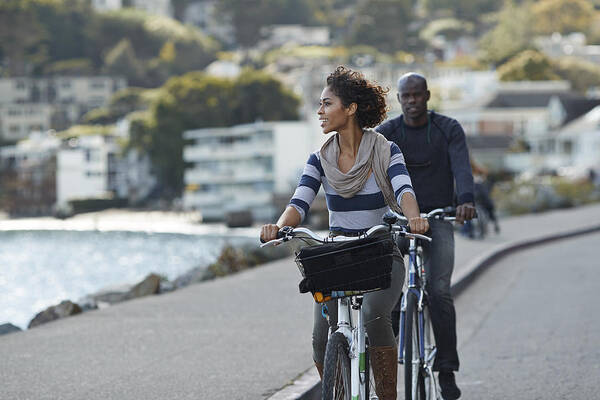 Water's Edge Art Print featuring the photograph Couple using rental bikes in the small town Sausalito by Klaus Vedfelt