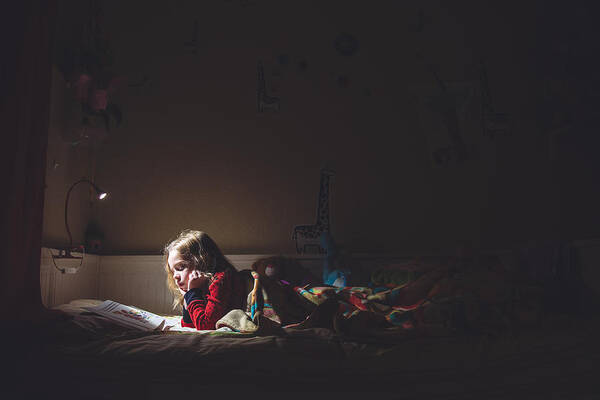 Child Art Print featuring the photograph Girl reading in her bed at night by Teresa Short