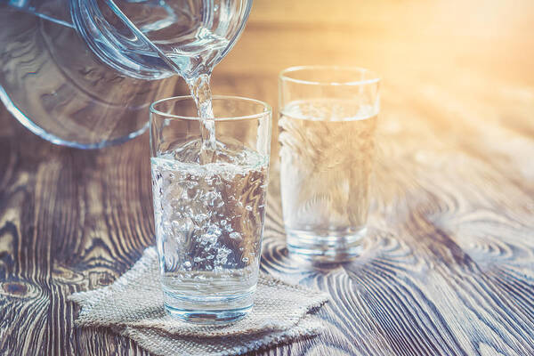 Care Art Print featuring the photograph Glass of water on a wooden table by YSedova