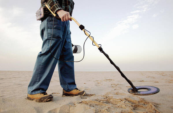 People Art Print featuring the photograph Man using metal detector at beach by Hill Street Studios