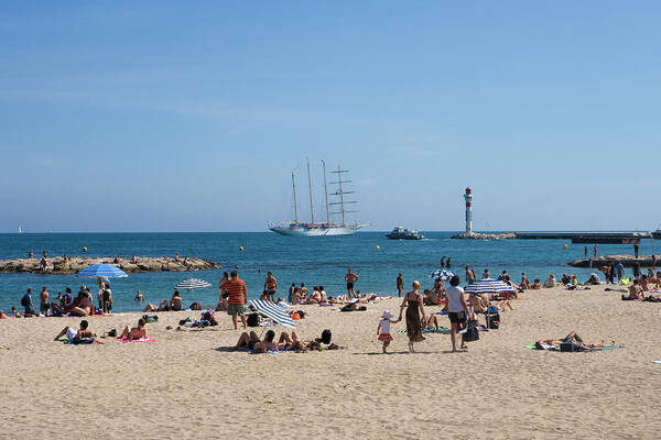 People Art Print featuring the photograph People Sunbathing On Beach With Sailing by Holger Leue