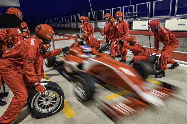 Crash Helmet Art Print featuring the photograph Red formula race car leaving the pit stop by Vm