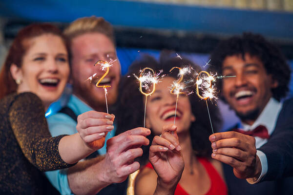 Young Men Art Print featuring the photograph Smiling people holding sparklers by RgStudio