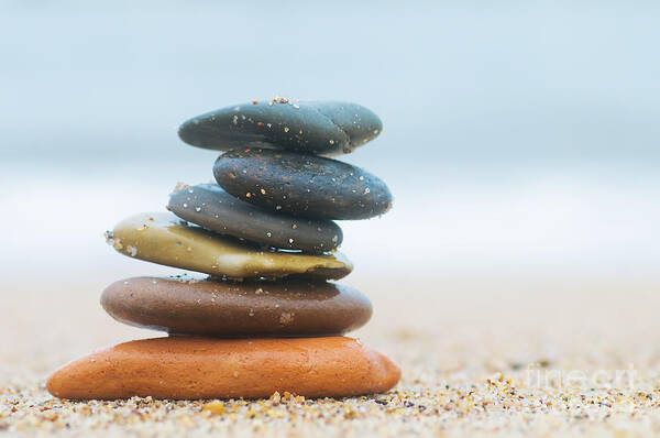 Stone Art Print featuring the photograph Stack of beach stones on sand by Michal Bednarek