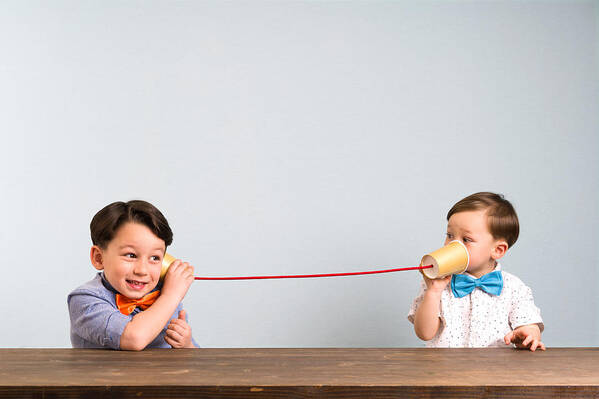 4-5 Years Art Print featuring the photograph Two childeren are using paper cups as a telephone by Pinstock