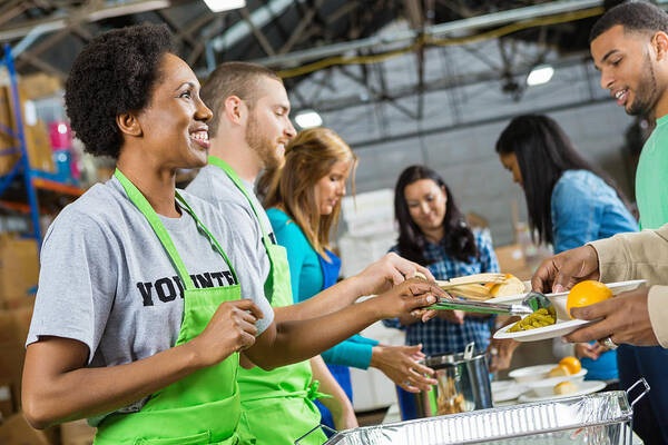 Working Art Print featuring the photograph Volunteers serving healthy hot meal at soup kitchen by SDI Productions