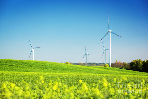 Wind Art Print featuring the photograph Wind turbines on spring field by Michal Bednarek