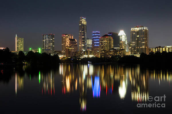 Austin Skyline Pictures Art Print featuring the photograph The glimmering Austin Skyline sparkles at night with a view from the Boardwalk Trail on Lady Bird Lake by Dan Herron