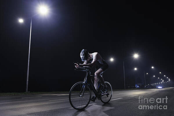Headwear Art Print featuring the photograph Cyclist Riding At Night In The City #2 by Stanislaw Pytel