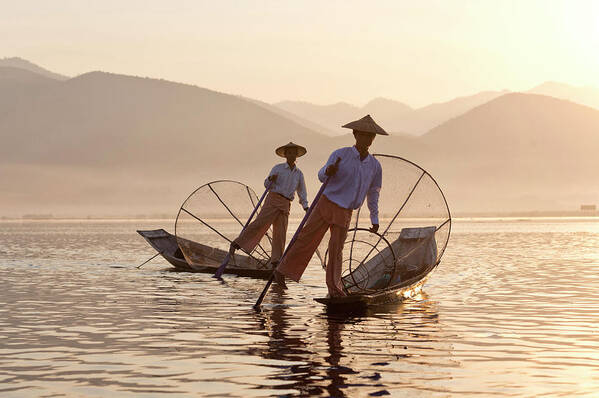 Intha 'leg Rowing' Fishermen At Sunset On Inle Lakeswho Row Traditional Wooden Boats Using Their Leg And Fish Using Nets Stretched Over Conical Bamboo Frames Art Print featuring the photograph 321-5141 by Robert Harding Picture Library