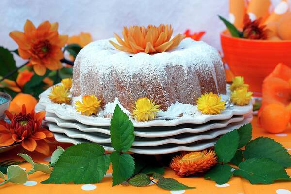 Ip_11182295 Art Print featuring the photograph A Bundt Cake Coated With Icing Sugar And Decorated With Orange Flowers by Linnhoff, Angelica