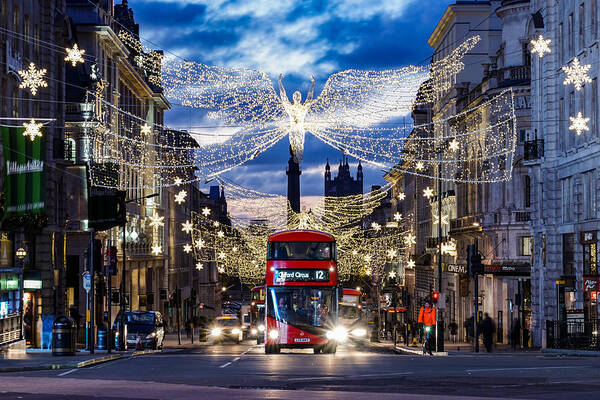 London Art Print featuring the photograph An iconic double decker red bus in London, England, at Piccadilly circus during Christmas. by George Afostovremea