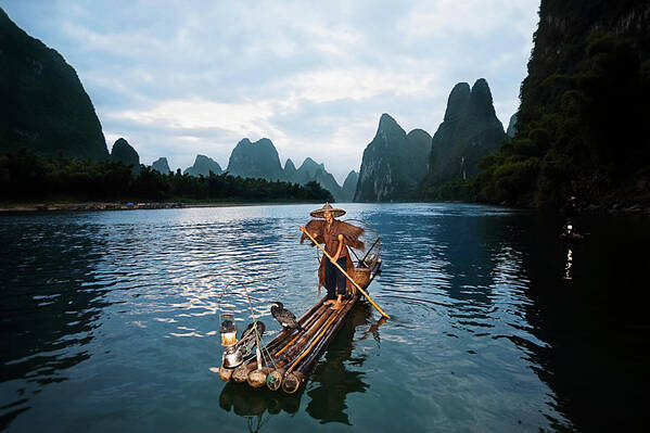 Chinese Culture Art Print featuring the photograph Fisherman Standing On A Wooden Raft In by Redchopsticks