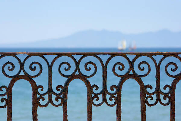 Water's Edge Art Print featuring the photograph Ornate Ironwork Railing With Ocean View by Yangyin