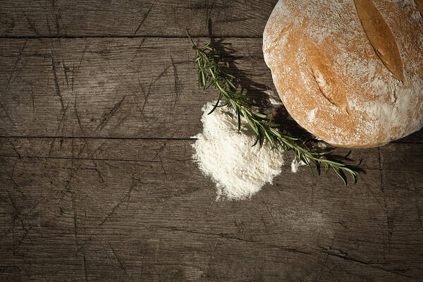 Bakery Art Print featuring the photograph Round Bread On A Wooden Table by Infrontphoto