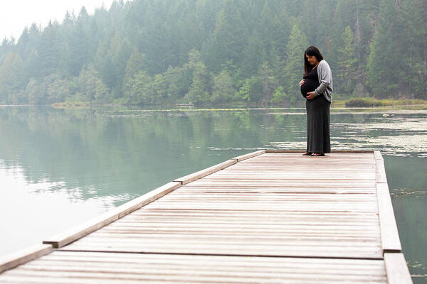 Unrecognizable Pregnant Woman Standing On Dock Looking At Her