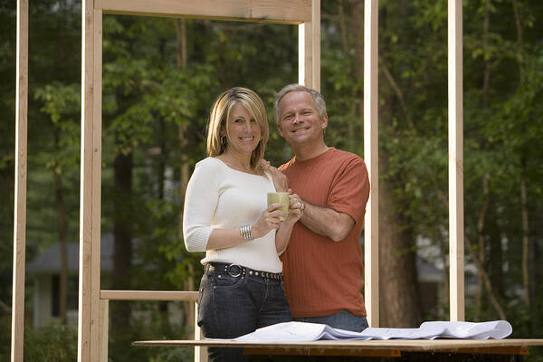 White People Art Print featuring the photograph Couple reviewing blueprints at construction site #1 by Comstock Images