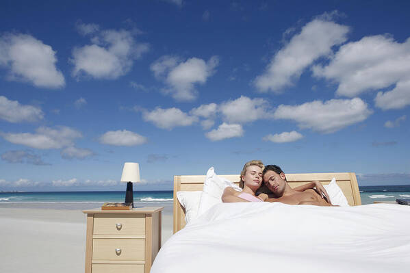 Mid Adult Men Art Print featuring the photograph Couple Sleeping in a Bed on the Beach #1 by Digital Vision.