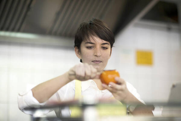 Focus Art Print featuring the photograph Young woman preparing food in fast food shop #1 by Sigrid Gombert