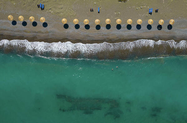  Beach Art Print featuring the photograph Aerial view from a flying drone of beach umbrellas in a row on a by Michalakis Ppalis