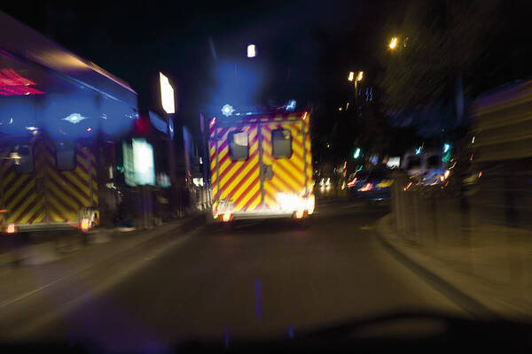 Ambulance Art Print featuring the photograph Ambulance driving on street at night by PhotoAlto/James Hardy