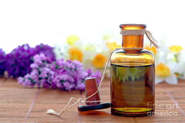 Amber Art Print featuring the photograph Aromatherapy Essential Oil Bottle with Flowers in a Spa by Olivier Le Queinec