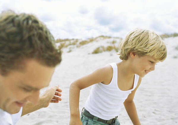 Young Men Art Print featuring the photograph Boy and father running on beach by Sigrid Olsson