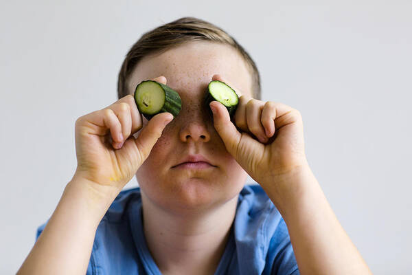 White People Art Print featuring the photograph Boy holding cucumber over eyes by Gombert, Sigrid/science Photo Library