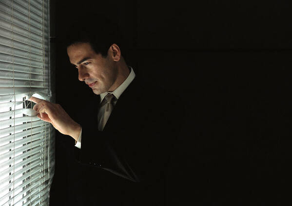 Corporate Business Art Print featuring the photograph Businessman looking through venetian blinds, portrait by Laurence Mouton