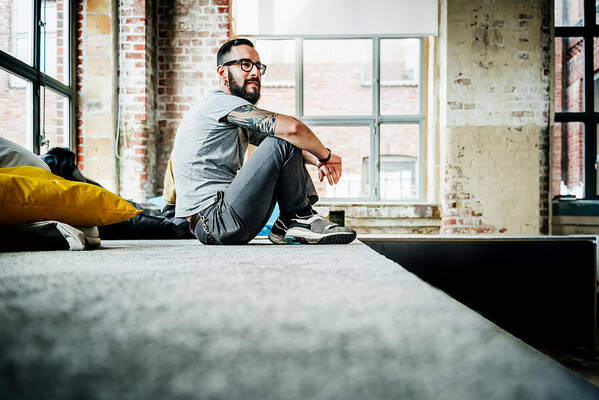 New Business Art Print featuring the photograph Casual business person sitting in office loft by Hinterhaus Productions