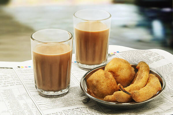 Unhealthy Eating Art Print featuring the photograph Close-up of morning chai with bhajiyas and vada on newspaper by Taka