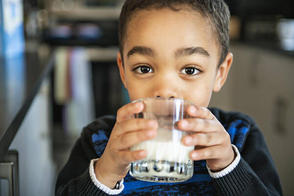 American Culture Art Print featuring the photograph Cute African American boy drinking milk at home by LSOphoto