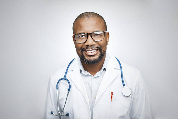 Expertise Art Print featuring the photograph Doctor wearing eyeglasses on white background by Morsa Images