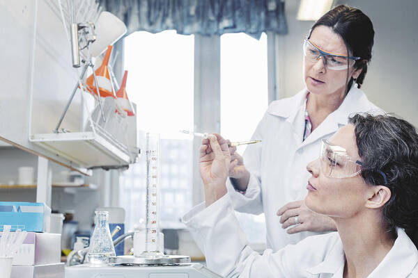 Expertise Art Print featuring the photograph Female scientists analyzing chemical in laboratory by Maskot