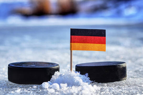 Germany Art Print featuring the photograph Germany flag on toothpick between two hockey pucks. Winter classic. Flag on frozen pond on unkempt ice. Traditional pucks for international matches. by Vaclav Sonnek