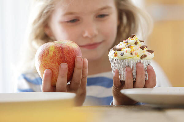 Part Of A Series Art Print featuring the photograph Girl choosing between an apple and a cake by Peter Cade