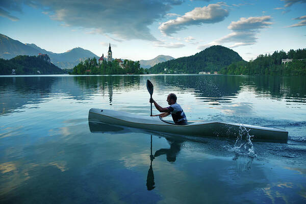 Bled Art Print featuring the photograph Man canoeing on Lake Bled by Ian Middleton