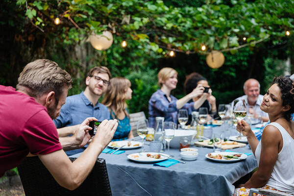 Young Men Art Print featuring the photograph Man Taking Photo Of Friends At Family BBQ by Hinterhaus Productions