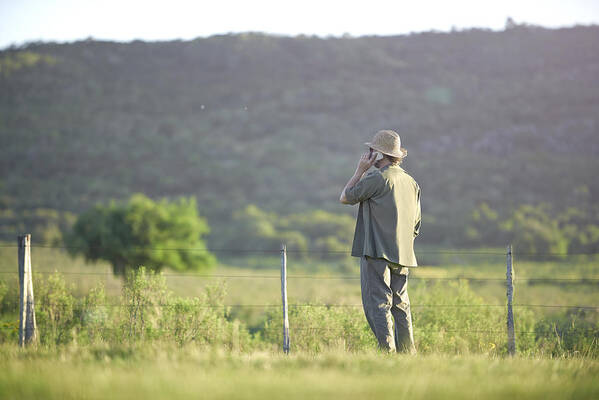 Scenics Art Print featuring the photograph Man talking with smartphone in landscape by Domino
