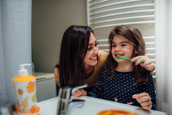 Toothbrush Art Print featuring the photograph Mother and daughter brushing teeth by RgStudio
