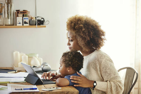 Child Art Print featuring the photograph Mother with son working on digital tablet at home by Morsa Images