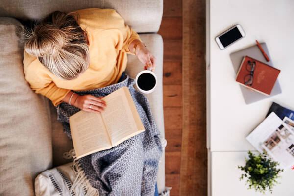 Internet Art Print featuring the photograph Overhead Shot Looking Down On Woman At Home Lying On Reading Book And Drinking Coffee by Monkeybusinessimages